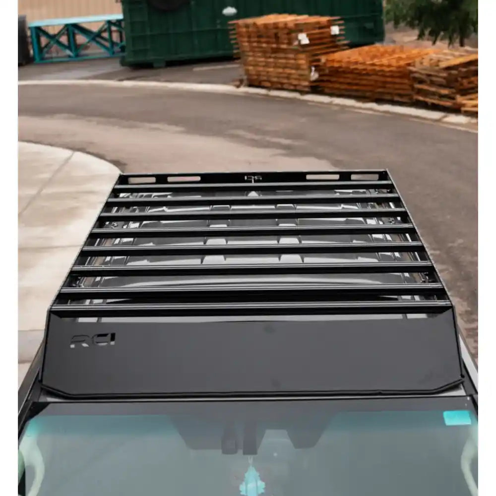 Overhead close-up of black RCI roof rack mounted on gray Lexus GX460 roof in outdoor storage area