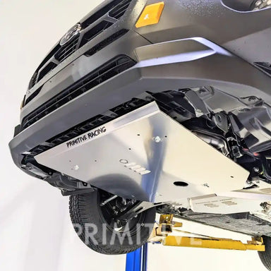 Close-up of a Crosstrek's undercarriage with 'Primitive Racing' branding  skid plates