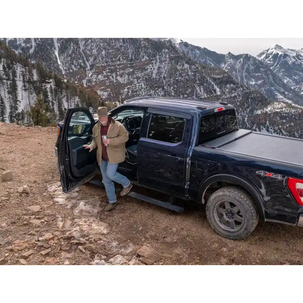 Person getting into a black truck in a mountainous area