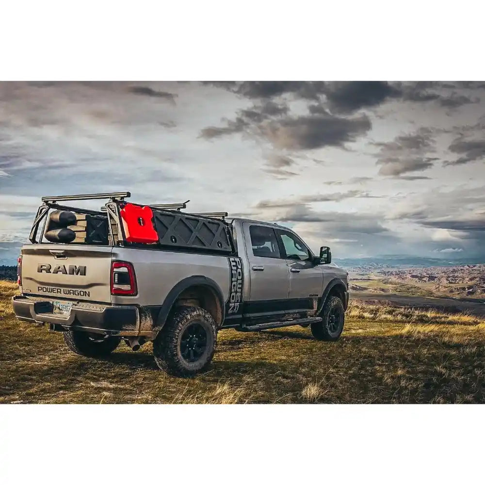 RAM truck with a bed rack in an open field under a cloudy sky