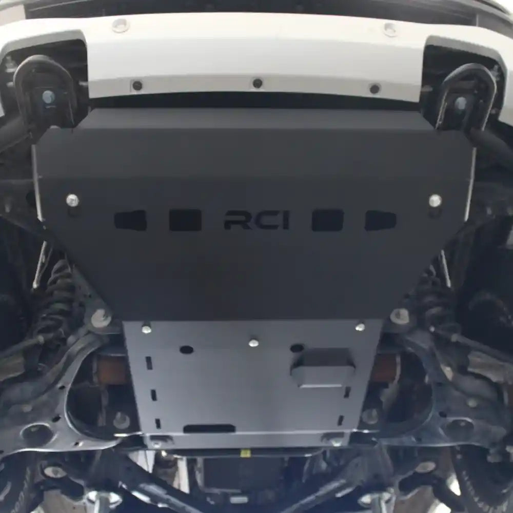 RCI front skid plate bolted under Ranger in workshop.