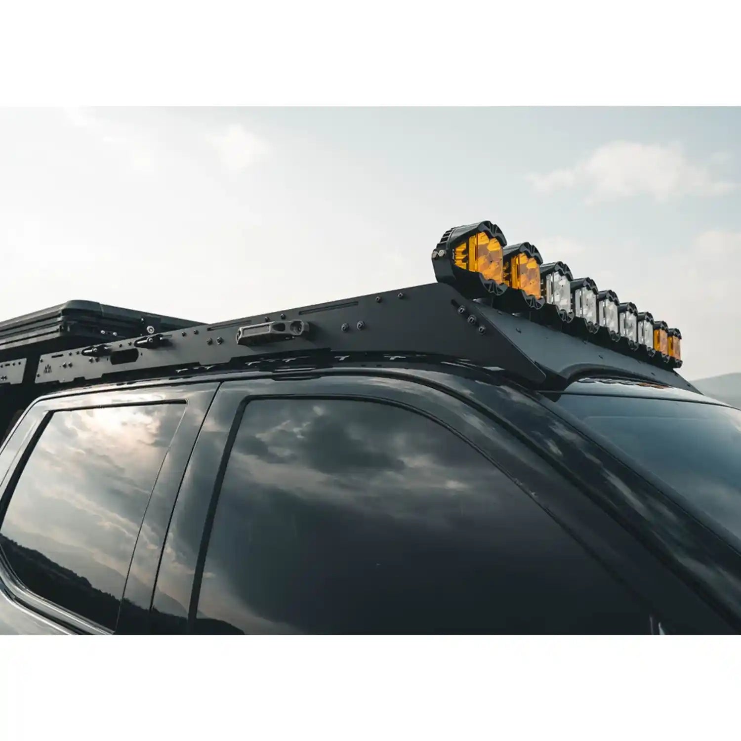 Roof rack with LED light bar on a vehicle against a cloudy sky