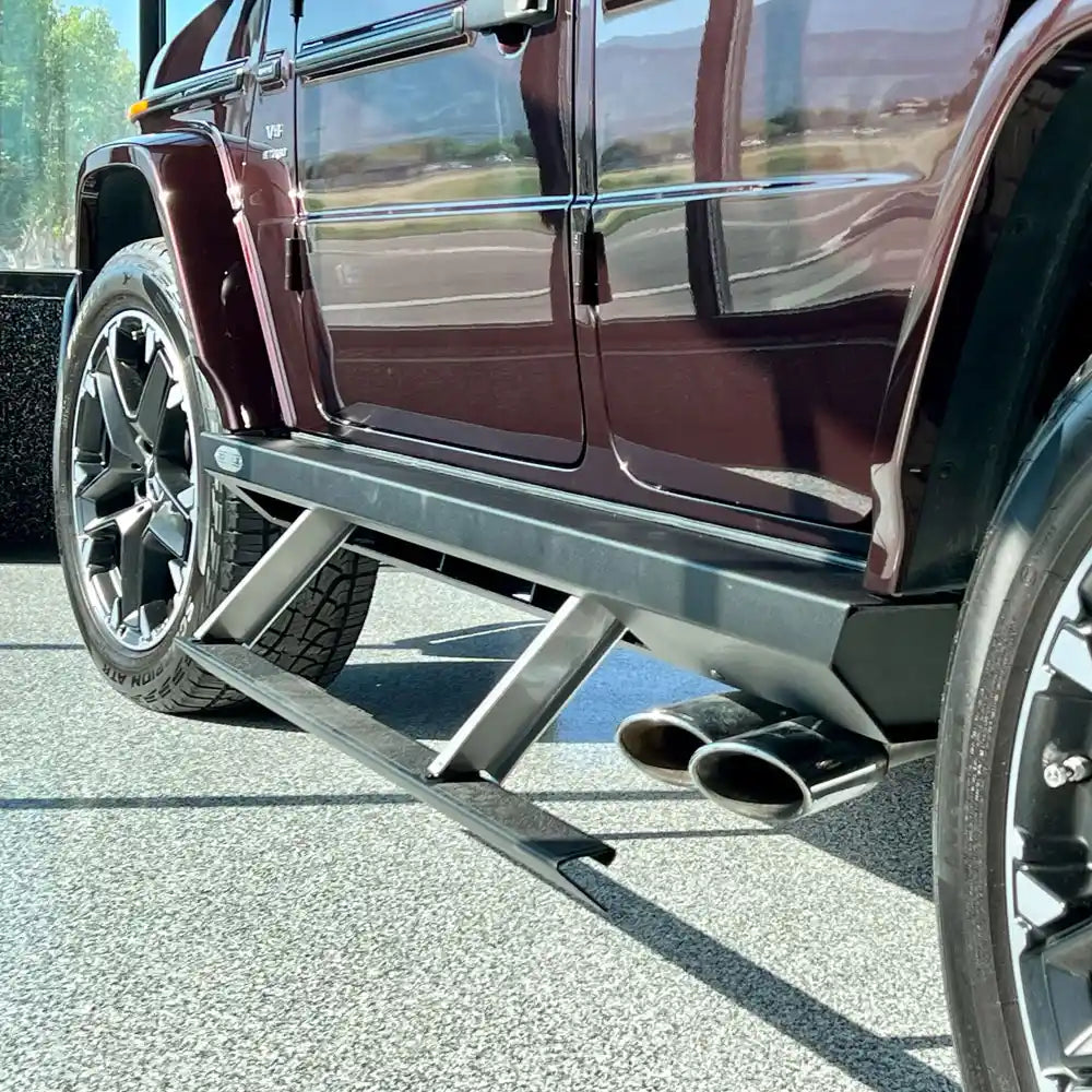 Rear three-quarter view of maroon G-Class with installed step sliders