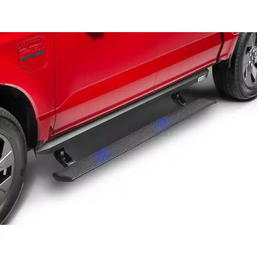 Red 2025 Ram 1500 with AMP Research PowerStep XL running boards extended, glowing with blue LED lights