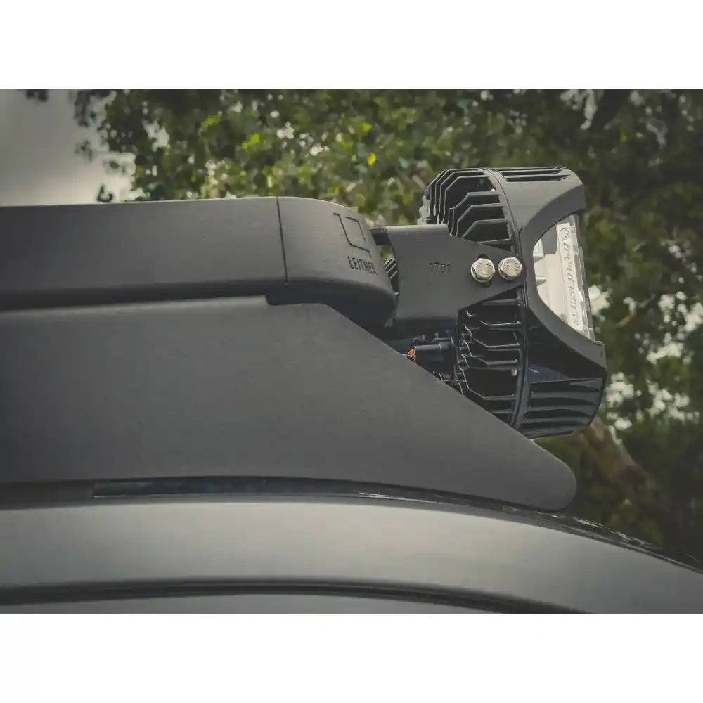 Roof-mounted light fixture on a vehicle with trees in the background