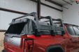 Red GMC truck with a truss bed rack in a warehouse setting