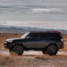 side view of Black 4runner with mounted southern  roof rack in a desert landscape with mountains in the background