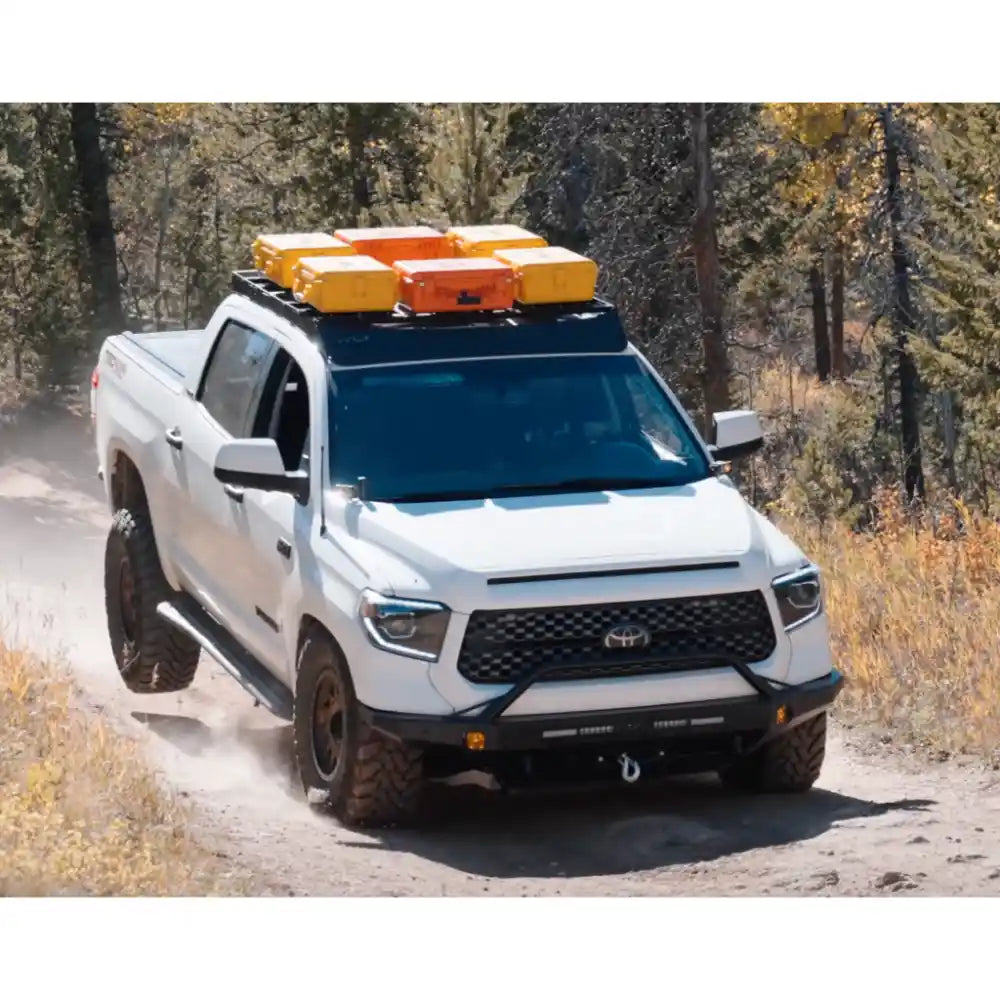 Silver Tundra with RCI rack and cargo boxes navigating rocky forest path