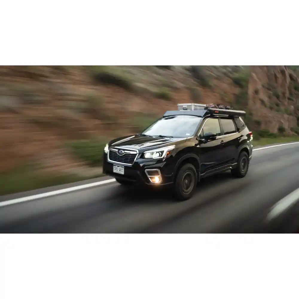 Subaru Forester driving on road with low-profile roof rack