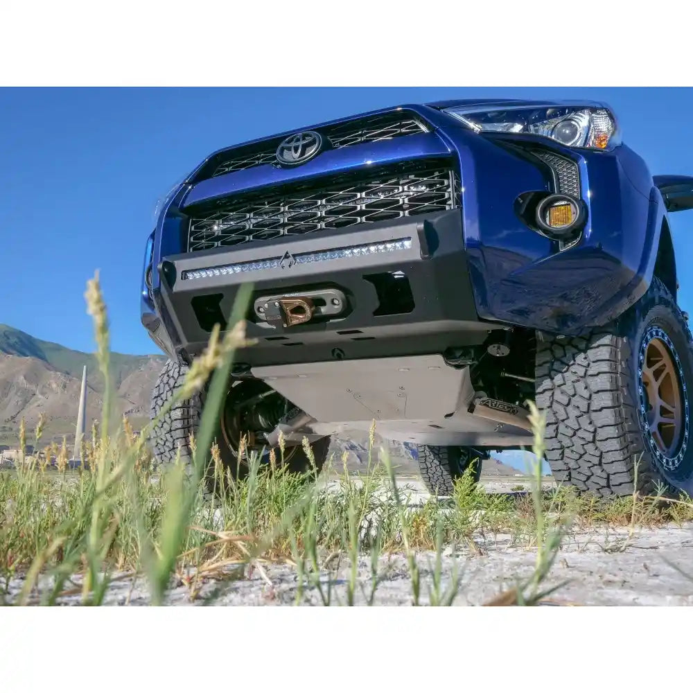 Blue 4Runner truck with mounted skid plates in a natural setting