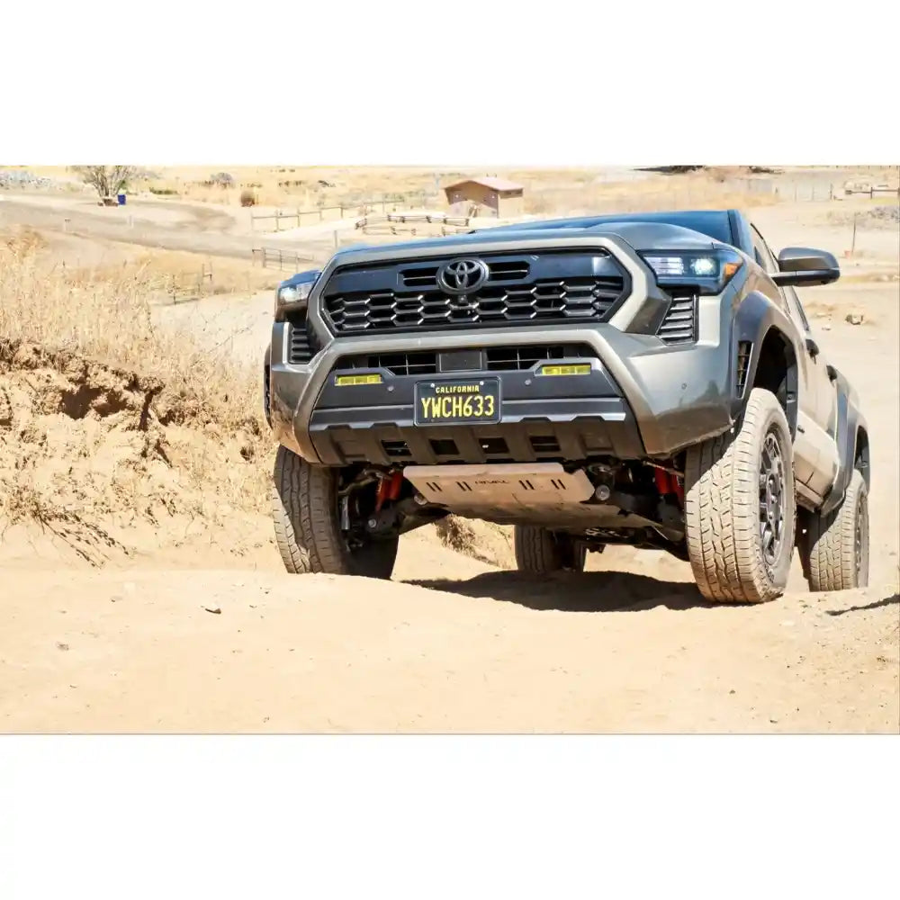 Toyota truck with Rival Skid Plate driving on a dirt road in a desert setting