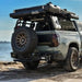 Toyota tundra truck with mounted Swing Out tire carrier, roof rack and off-road tires on a beach.