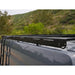 Transit roof rack mounted with a scenic background of trees and hills.