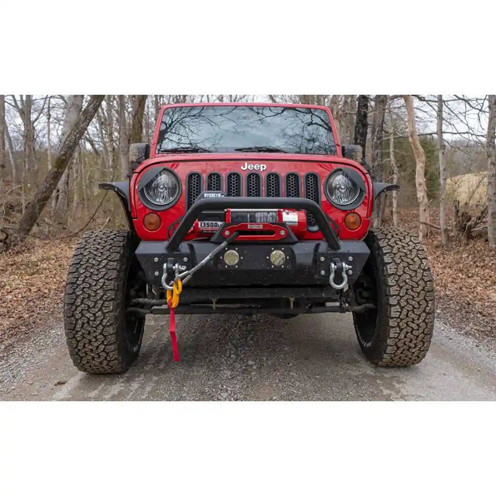 Warrior 13500lb electric winch mounted on a red Jeep Wrangler on a forest road