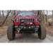 Warrior 13500lb electric winch mounted on a red Jeep Wrangler on a forest road