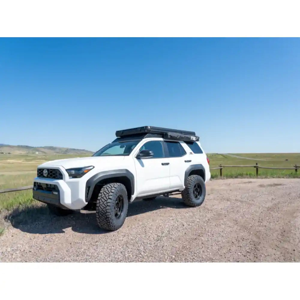 White 4Runner parked on mountain trail with RCI rack against rocky peaks and fence line