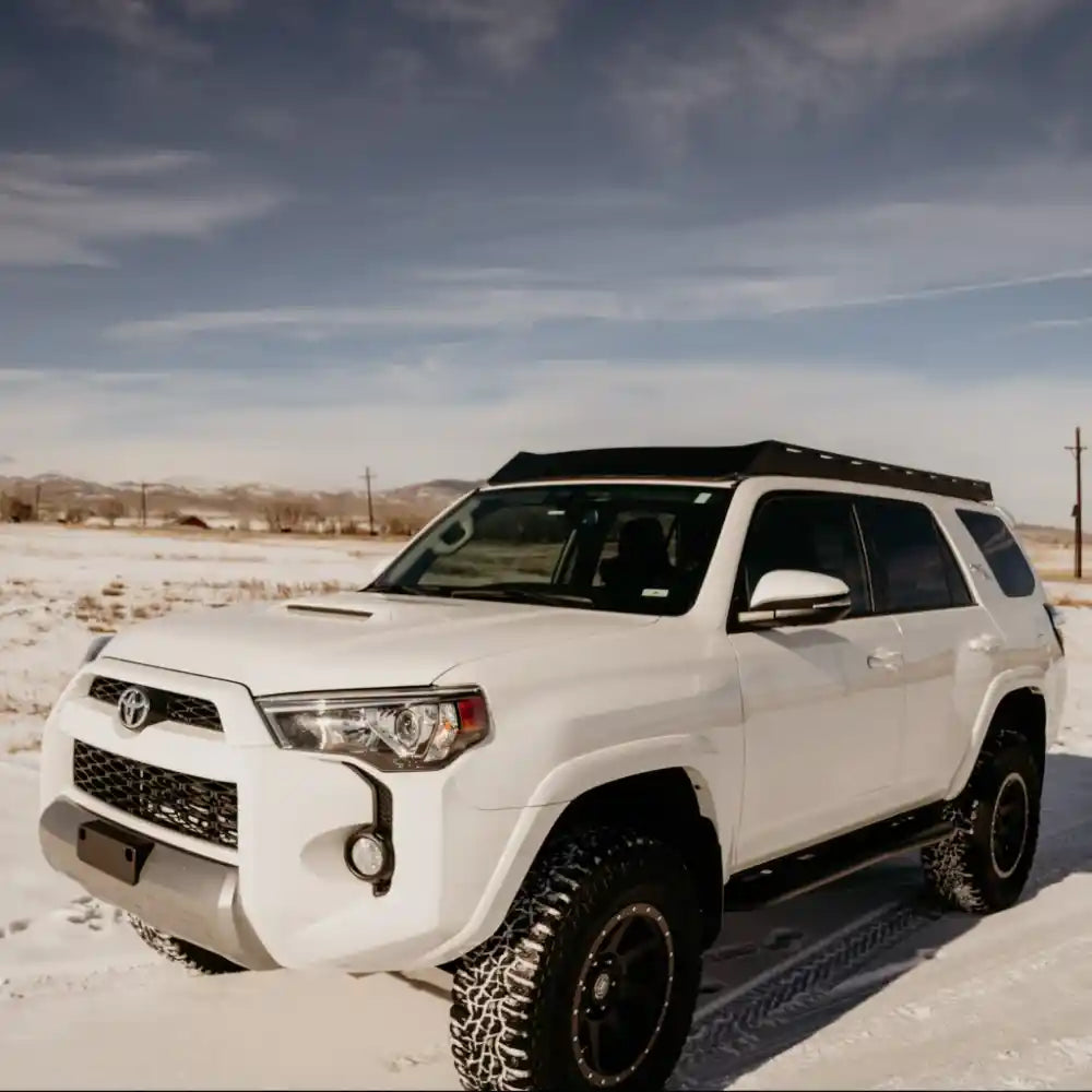 White 4Runner with roof rack in a snowy landscape
