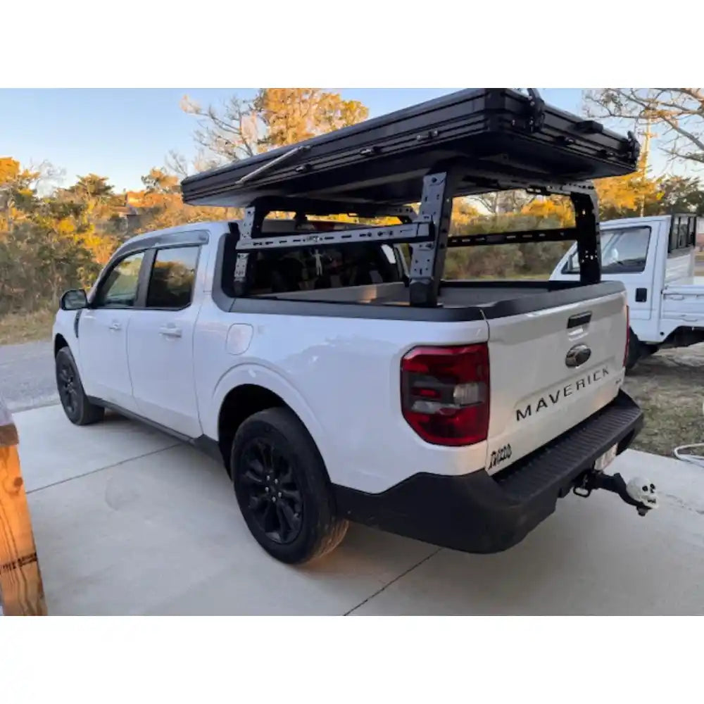 White Ford Maverick truck with an bed rack cargo on a driveway.