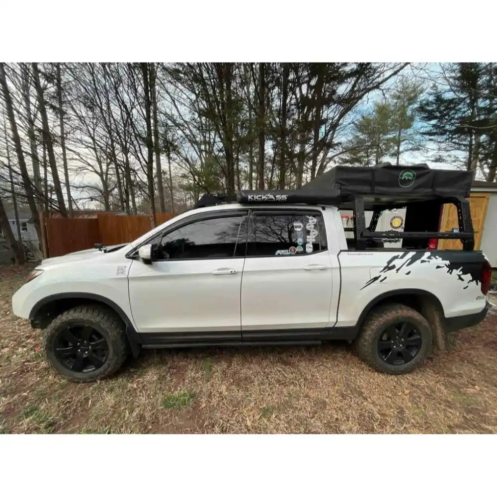 White Honda Ridgeline with a black bed rack by TUWA Pro and cargo bed cover in a wooded area