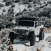 White Jeep Rubicon in a snowy landscape with mounted TrailRax Rack