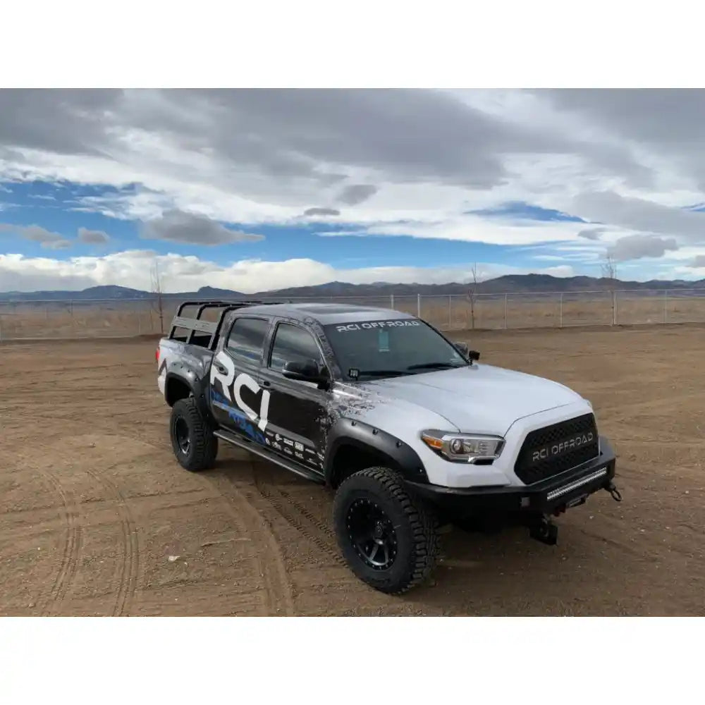 White Toyota Tacoma with RCI Offroad HD bed rack installed in desert setting