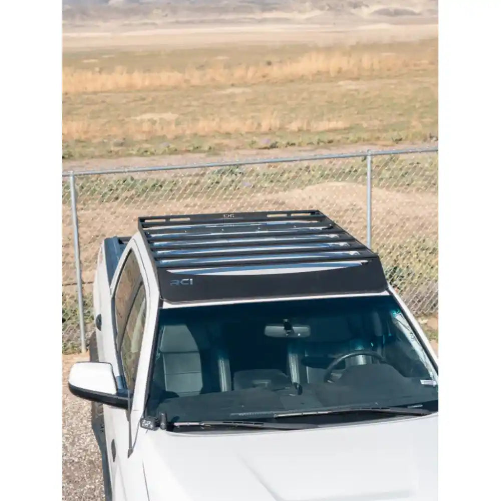 White Tundra parked in open prairie with mounted RCI roof rack against fence