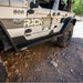 Wrangler on a rocky trail with 'Rock Slide Engineering' closed step sliders.