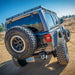 Close low-angle rear view of a Jeep Wrangler JL 4-Door with the DV8 Offroad Roof Rack, showing the DV8 logo and spare tire