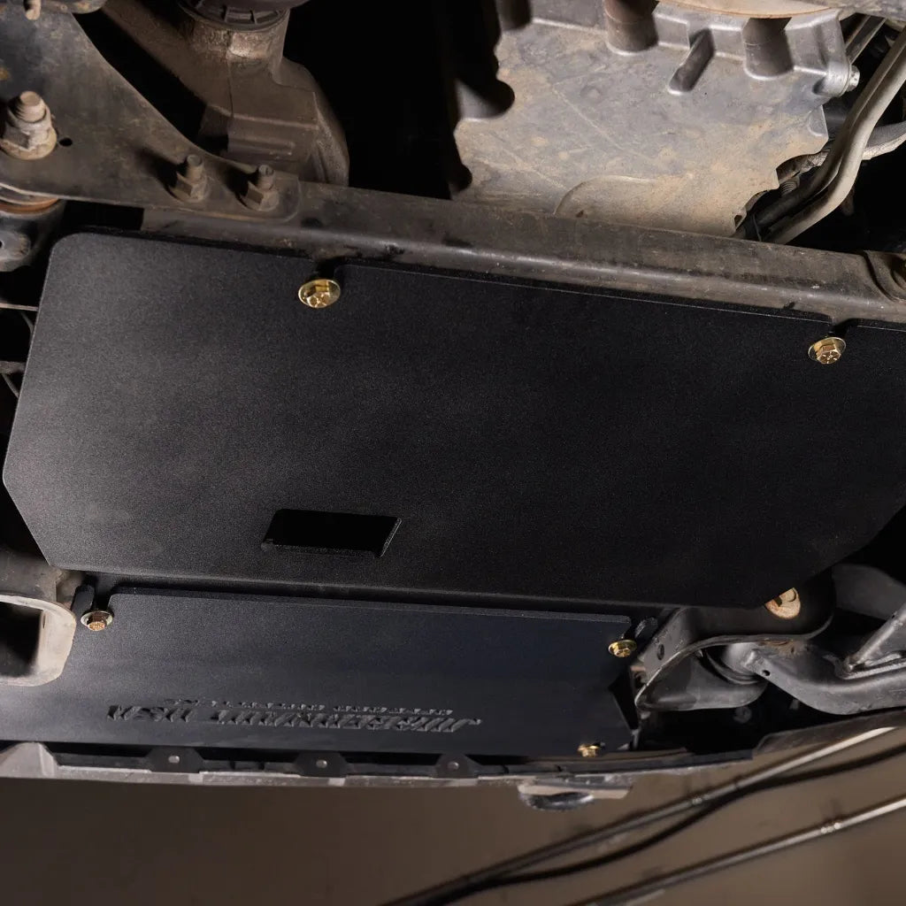Underside view of a Ford Expedition showing the Juggernaut engine skid plate covering the oil pan and intercooler area