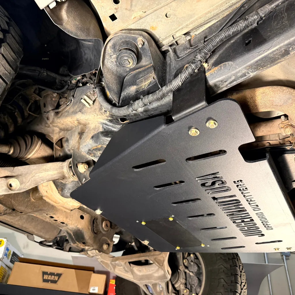Juggernaut transmission skid plate installed along the rear frame rail of a 2009-2014 Ford F-150