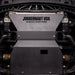 Juggernaut Ford F-150 engine skid plate installed, straight-on underbody view showing the embossed JUGGERNAUT USA logo behind the front bumper