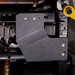 Close-up underbody view of the Ford F-150 transfer case skid plate installed near the driveshaft, mounted with visible bolts