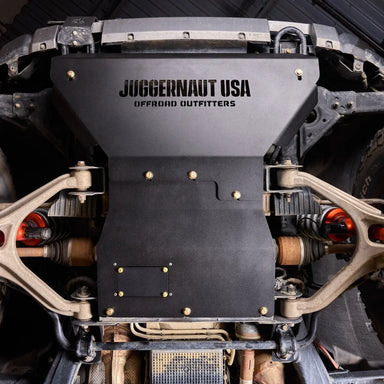 Close-up underbody view of the Juggernaut engine skid plate oil drain access panel