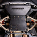Close-up underbody view of the Juggernaut engine skid plate oil drain access panel