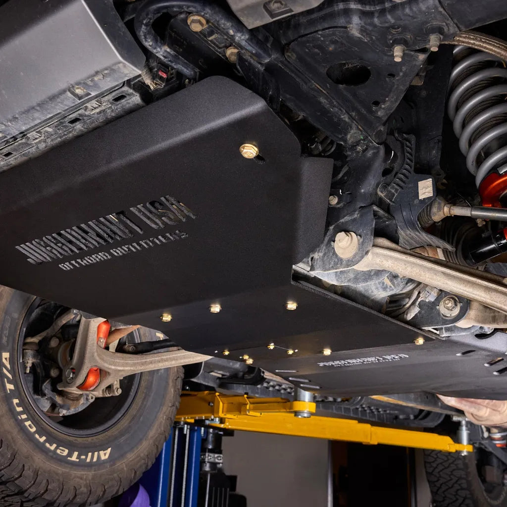 Ford Ranger Raptor on a lift showing the complete Juggernaut skid plate package from intercooler to transfer case