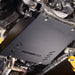 Angled underbody view of the transmission skid plate mounted near the exhaust pipe