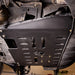Ford Transit on a trail, angled underbody view of the Juggernaut engine skid plate