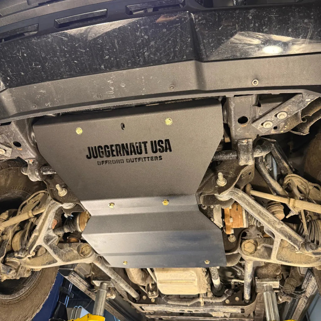 Straight-on underbody view of the Juggernaut USA Silverado 2500HD/3500HD engine skid plate mounted low between the front subframe rails