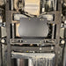 Underbody view of the Juggernaut USA transfer case skid plate mounted between the frame rails, with the fuel tank visible above