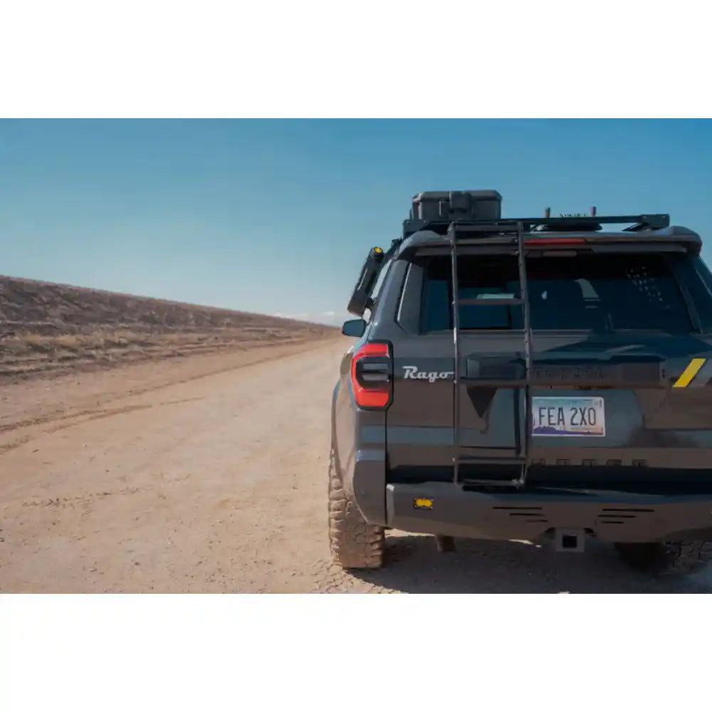 Toyota 4Runner with Rago hatch ladder on gravel road, rear three-quarter