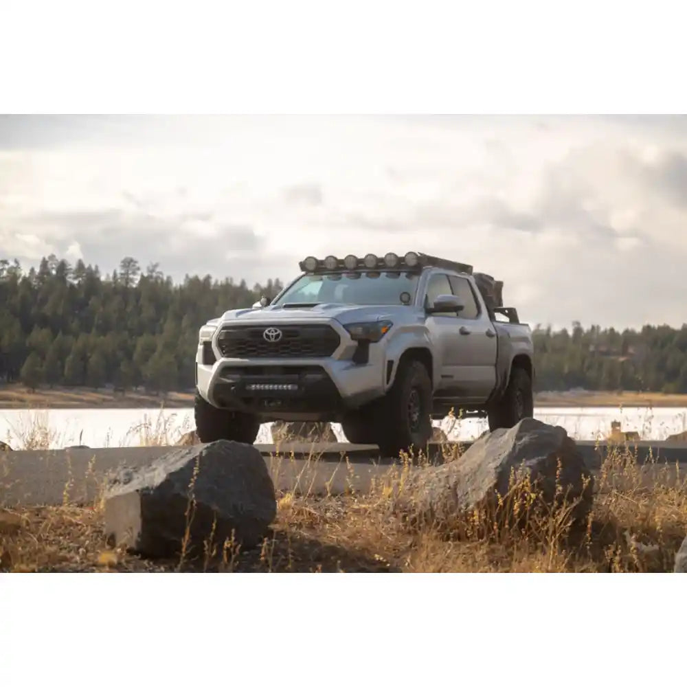 Toyota Tacoma by a lake with Rago round light mount on roof rack