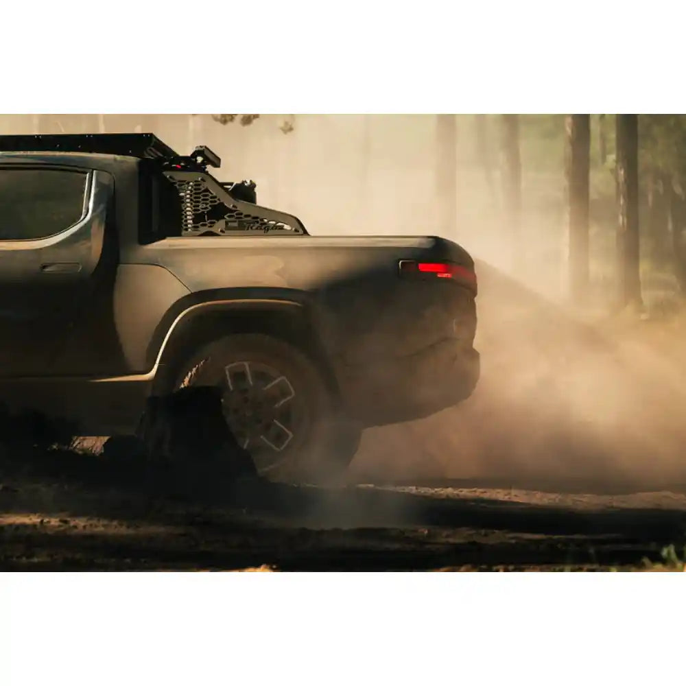 Rivian R1T with Rago chase rack kicking up dust on trail
