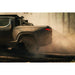 Rivian R1T with Rago chase rack kicking up dust on trail