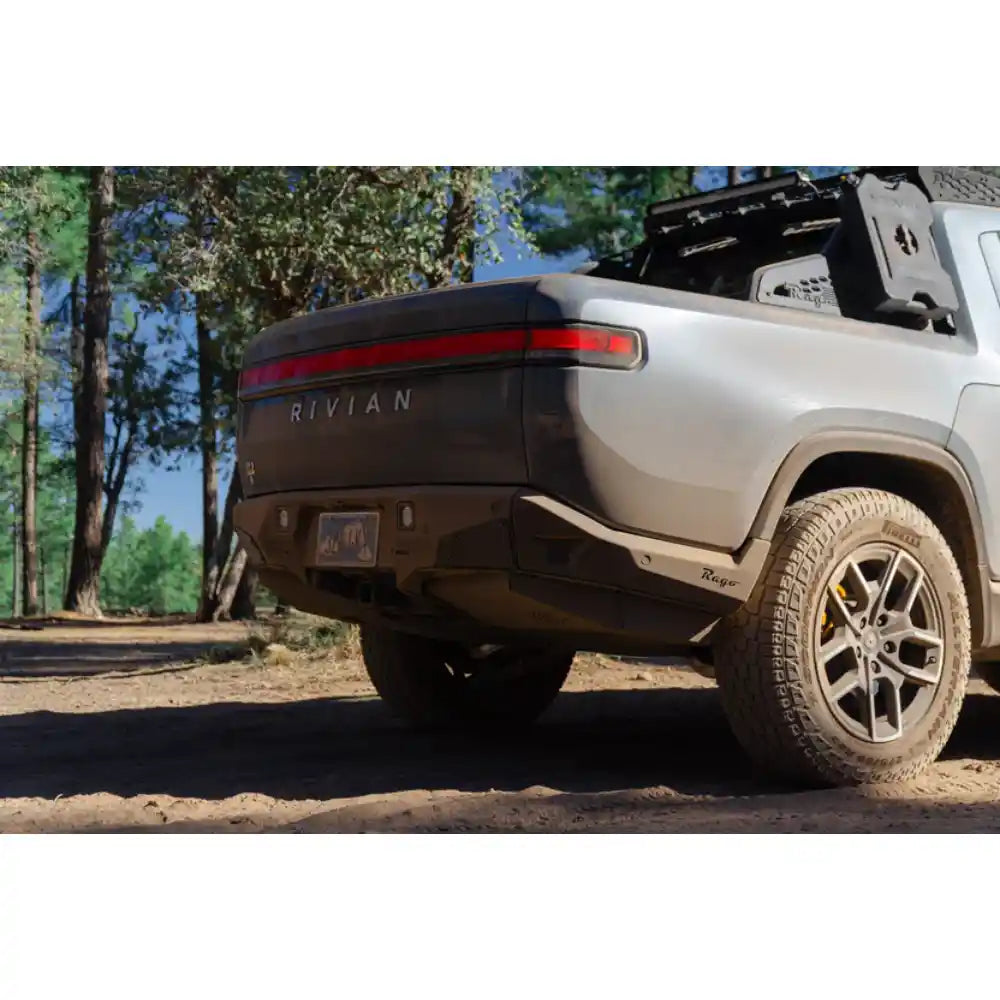 Rivian R1T with Rago chase rack in forest, rear three-quarter