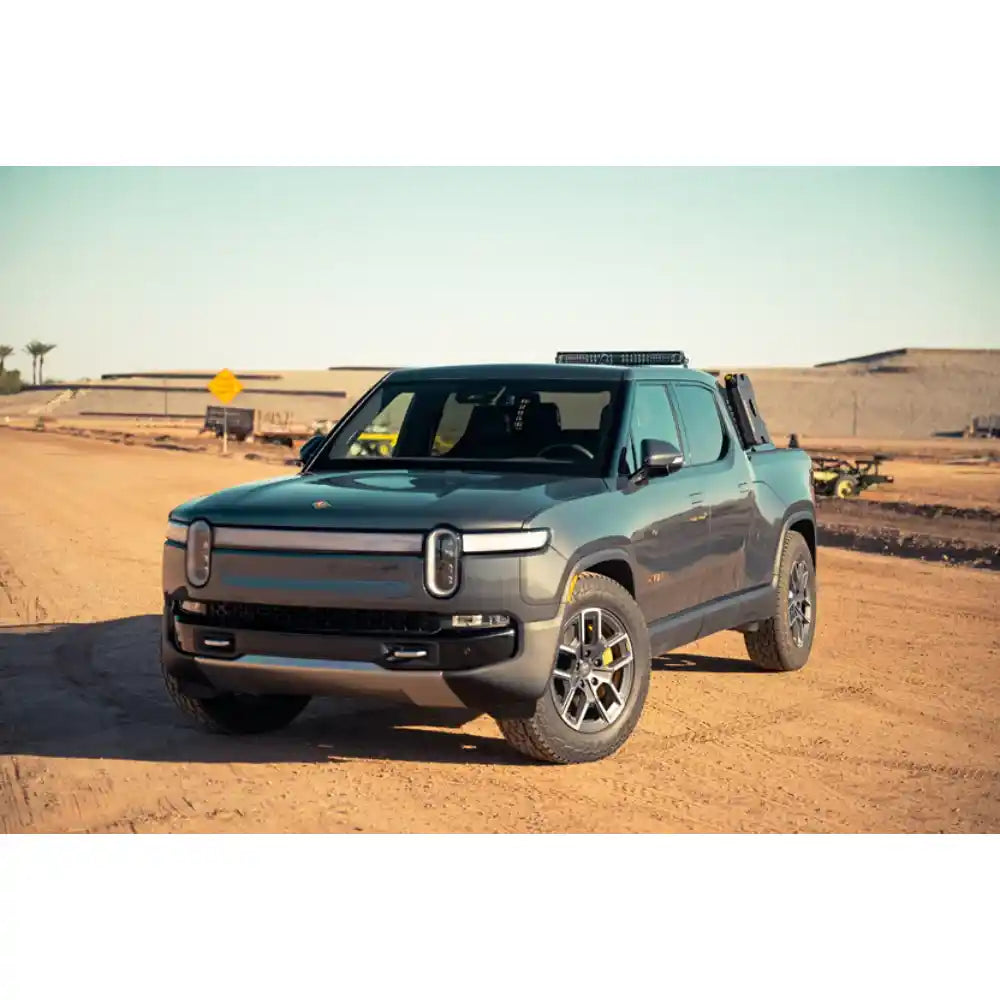 Rivian R1T with Rago chase rack, front three-quarter in desert