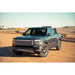 Rivian R1T with Rago chase rack, front three-quarter in desert