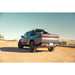 Rivian R1T with Rago chase rack in desert, rear three-quarter