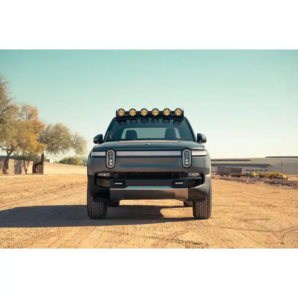 Rivian R1T with RIGID round lights on Rago roof rack, front view in desert