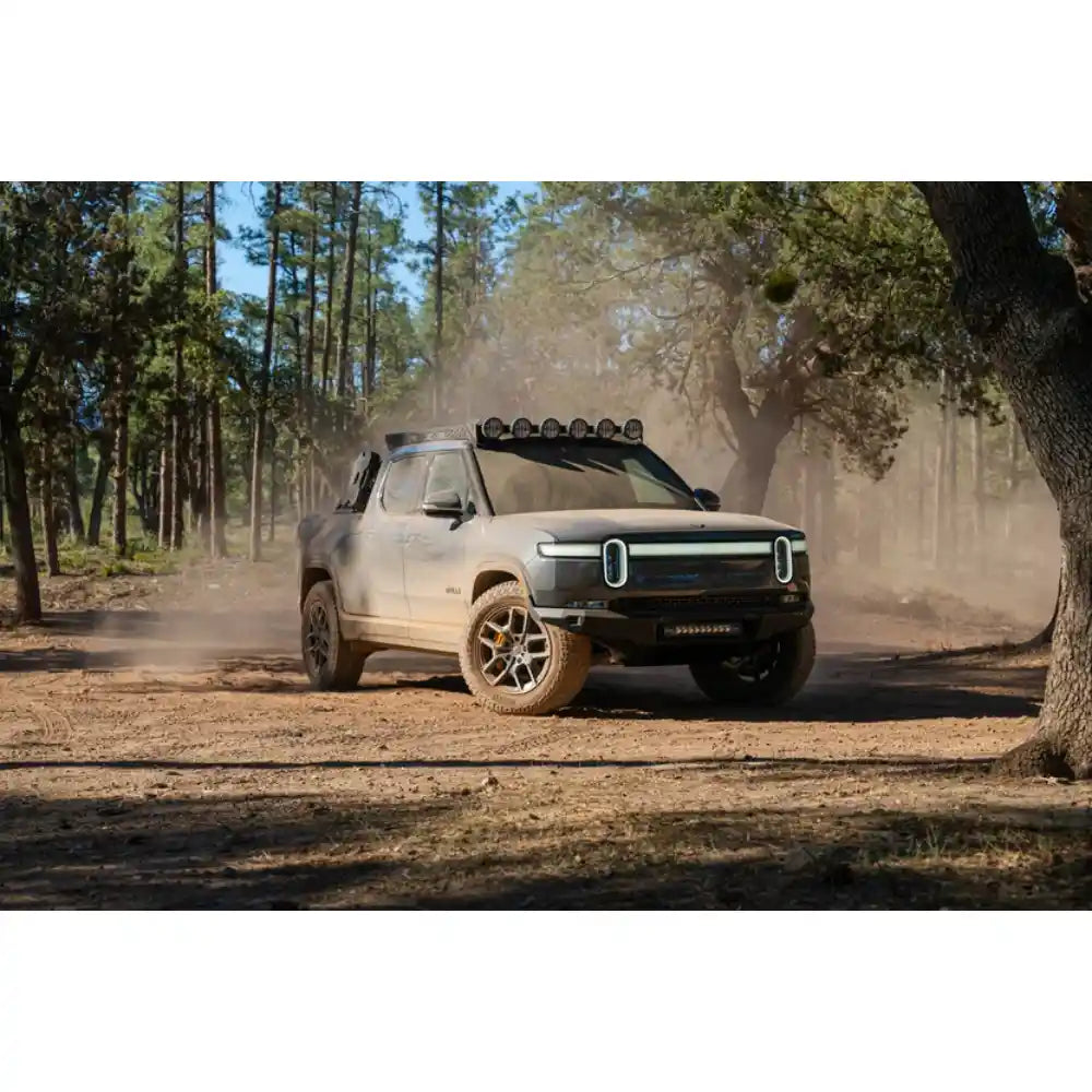 Rivian R1T with Rago roof rack driving on dusty trail