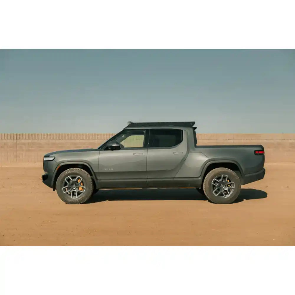 Rivian R1T side profile with Rago light pocket roof rack in desert